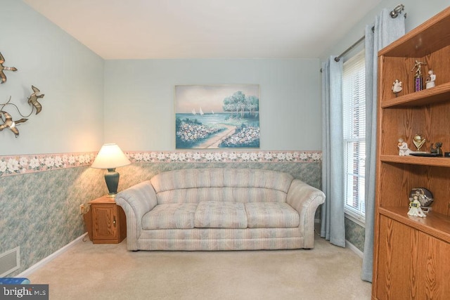 carpeted living area featuring visible vents, baseboards, and wallpapered walls