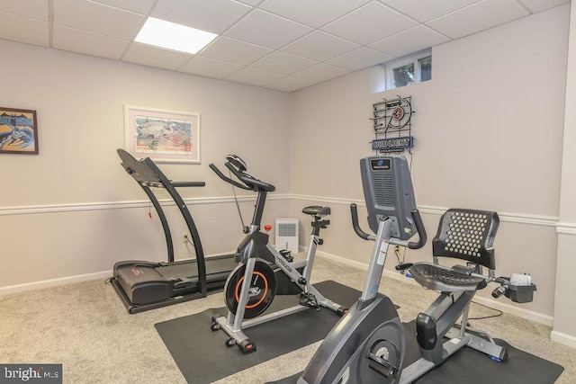 workout area featuring carpet flooring, a paneled ceiling, and baseboards