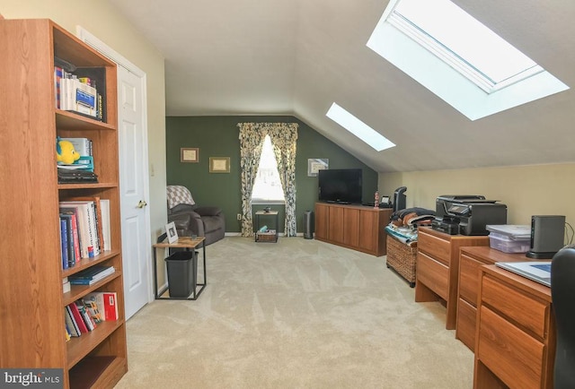 office space featuring light carpet and vaulted ceiling with skylight