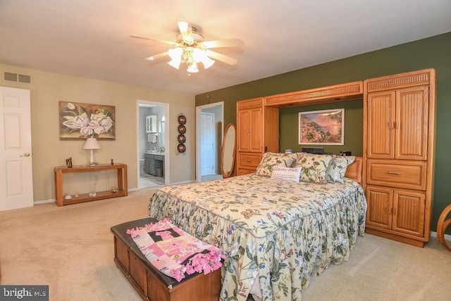 bedroom with visible vents, a ceiling fan, connected bathroom, baseboards, and light colored carpet