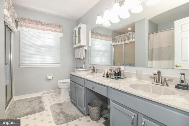 full bath with a sink, a healthy amount of sunlight, and double vanity