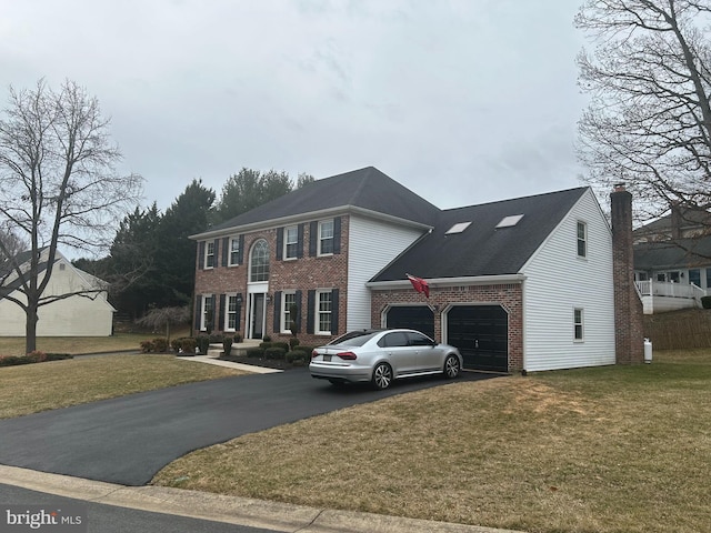 view of front of house with brick siding, driveway, a front yard, and a garage