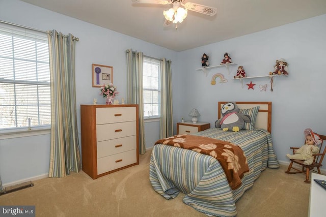 bedroom featuring a ceiling fan, baseboards, visible vents, and light carpet