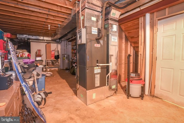 unfinished below grade area featuring heating unit and electric water heater