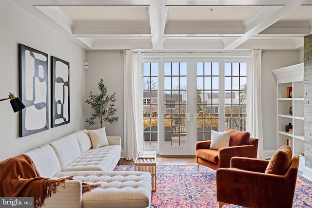 interior space with beam ceiling, coffered ceiling, crown molding, and wood finished floors