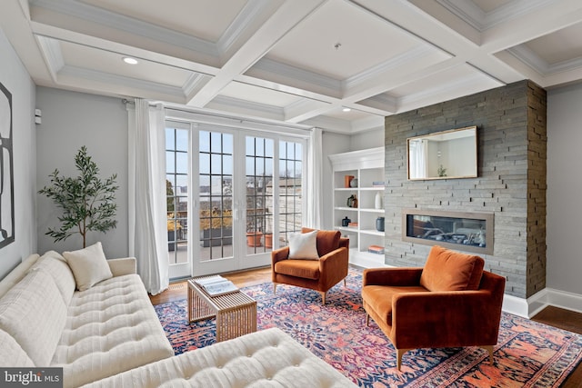 living area featuring coffered ceiling, a fireplace, wood finished floors, beam ceiling, and crown molding