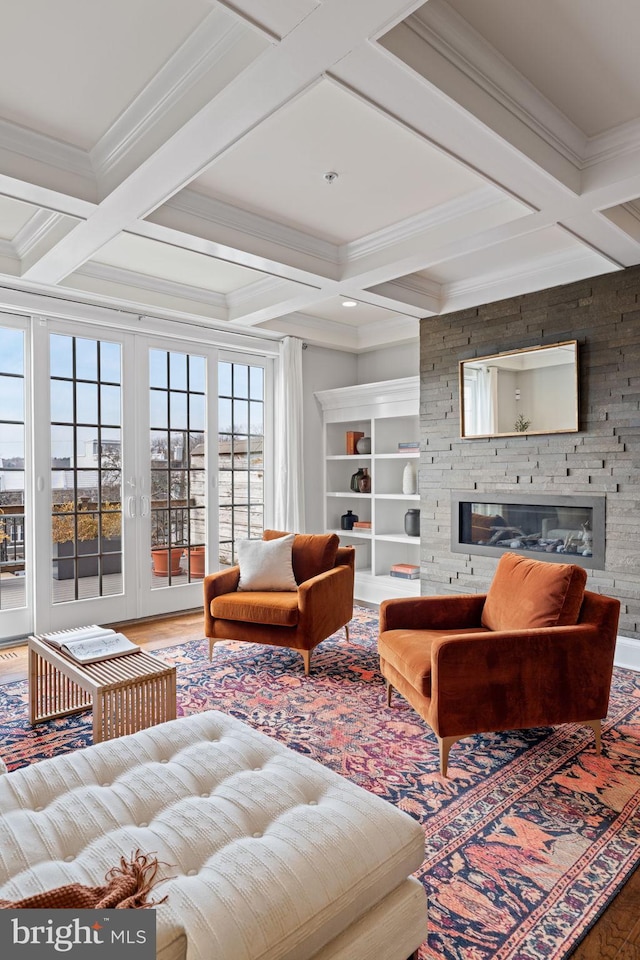 living room featuring french doors, beamed ceiling, a fireplace, and coffered ceiling