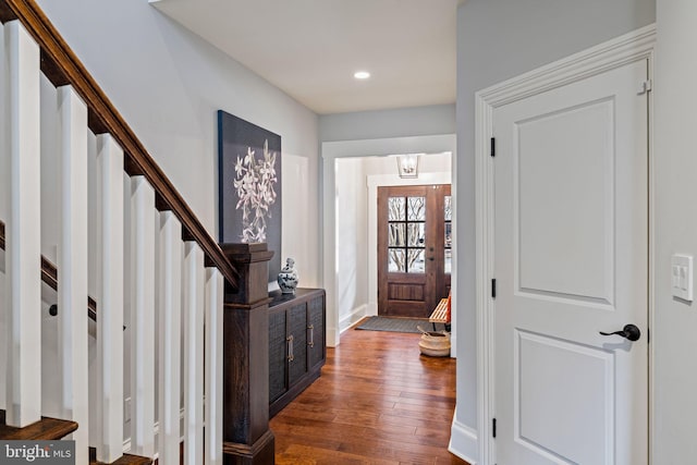 foyer entrance featuring dark wood-style floors, stairway, baseboards, and recessed lighting