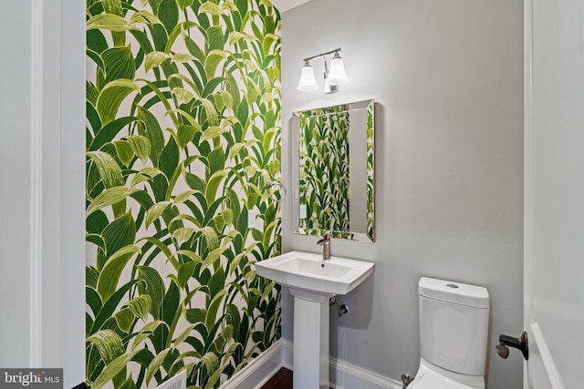 bathroom with toilet and baseboards