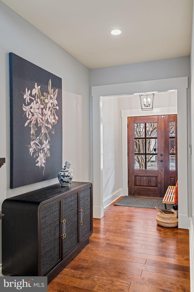 foyer entrance with a notable chandelier and wood finished floors