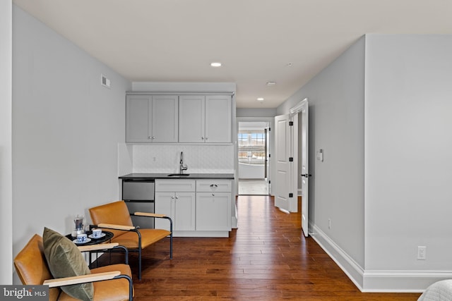 sitting room featuring dark wood-type flooring, recessed lighting, visible vents, and baseboards