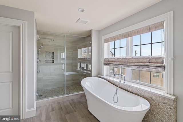 bathroom featuring a soaking tub, a shower stall, and visible vents