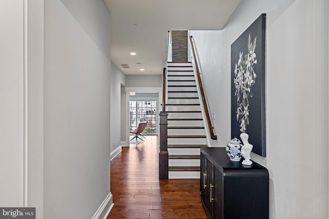 hallway with recessed lighting, dark wood-type flooring, visible vents, baseboards, and stairs