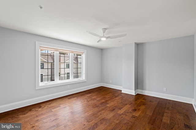 empty room with dark wood-style flooring, ceiling fan, and baseboards