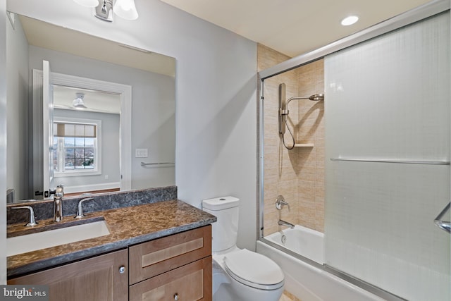 bathroom with bath / shower combo with glass door, vanity, and toilet