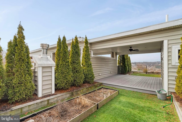 view of yard featuring a vegetable garden, a wooden deck, and ceiling fan