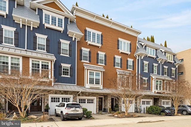 townhome / multi-family property featuring board and batten siding, stone siding, and an attached garage