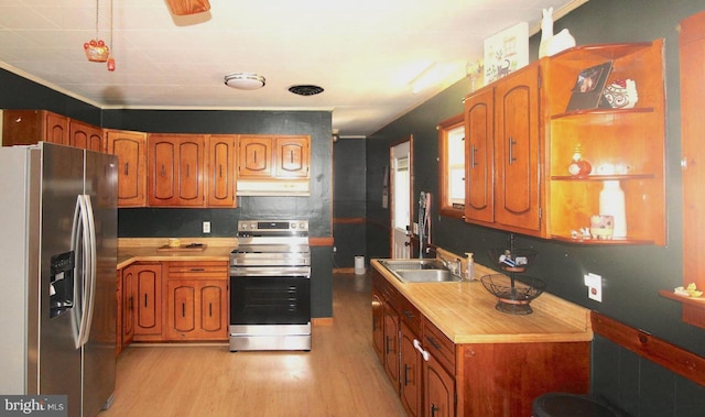 kitchen featuring stainless steel appliances, brown cabinets, a sink, and under cabinet range hood