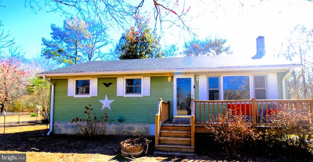 view of front of home featuring a chimney and a deck