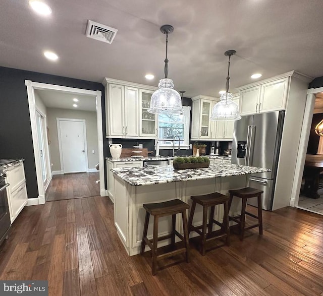 kitchen featuring visible vents, dark wood-type flooring, glass insert cabinets, and high end refrigerator