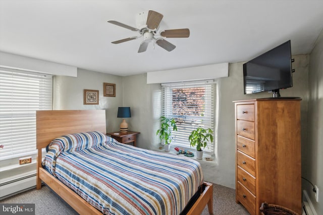 carpeted bedroom with baseboard heating and a ceiling fan