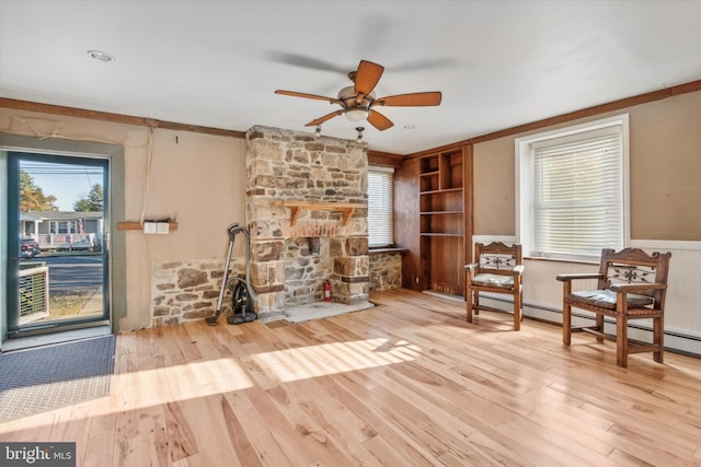 sitting room with a wainscoted wall, a fireplace, and wood finished floors