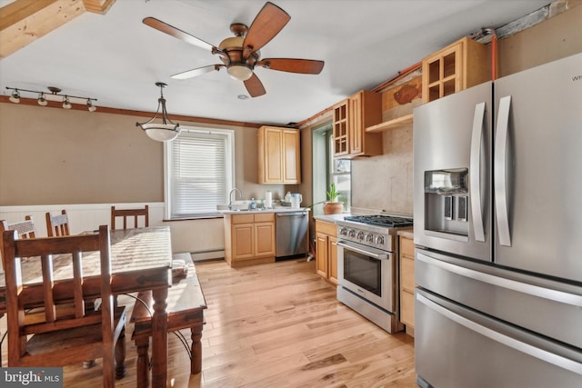 kitchen with appliances with stainless steel finishes, light countertops, light brown cabinetry, light wood-style floors, and a sink