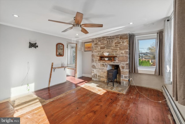 unfurnished living room featuring crown molding, a baseboard heating unit, and hardwood / wood-style floors