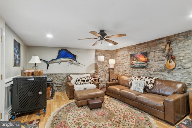 living room featuring a wainscoted wall, ceiling fan, and wood finished floors