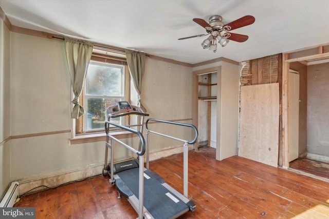 workout area with a baseboard heating unit, hardwood / wood-style floors, and a ceiling fan