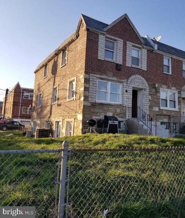 multi unit property with stone siding, brick siding, and fence