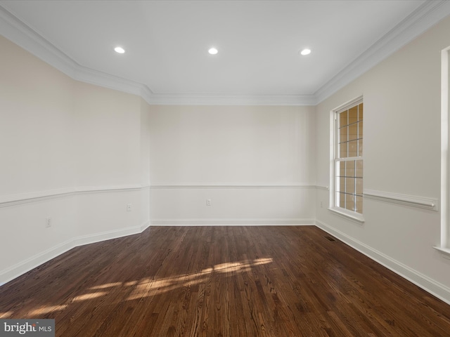 empty room with dark wood-style floors, baseboards, and crown molding