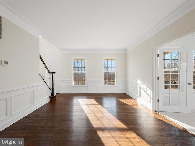 entrance foyer with stairs, a wainscoted wall, wood finished floors, and crown molding