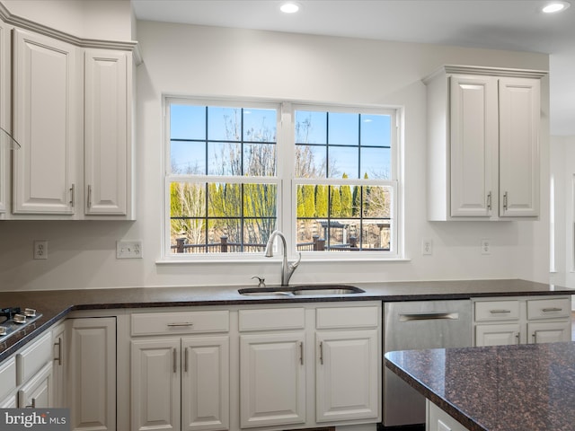 kitchen with appliances with stainless steel finishes, white cabinetry, and a sink