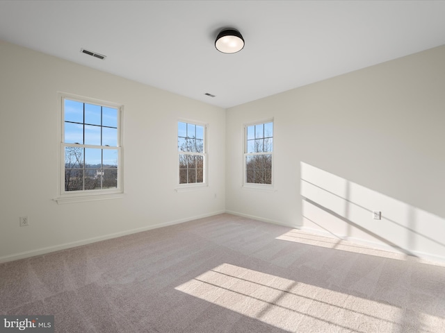 carpeted empty room with visible vents and baseboards