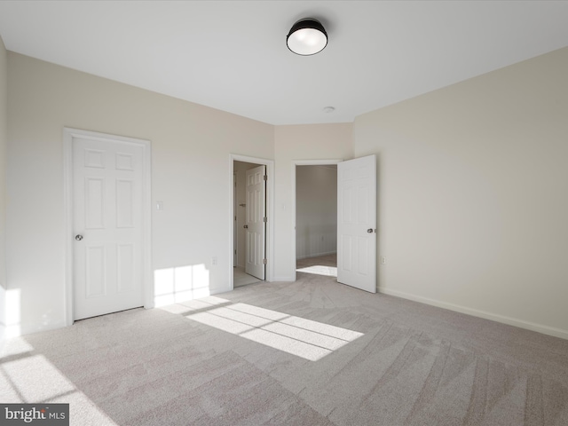 unfurnished bedroom featuring baseboards and light colored carpet