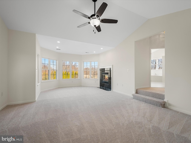 unfurnished living room featuring baseboards, a tile fireplace, lofted ceiling, carpet flooring, and recessed lighting