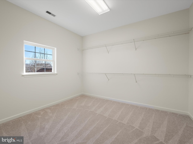 walk in closet with light carpet and visible vents