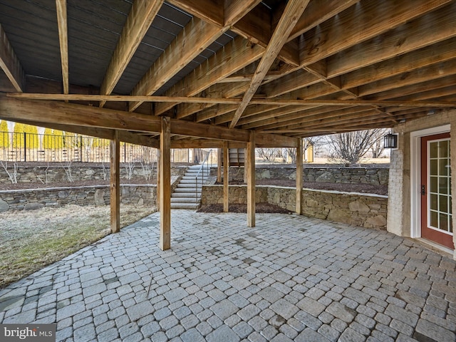 view of patio with fence and stairway