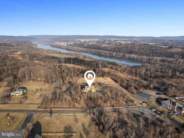 drone / aerial view featuring a wooded view and a water and mountain view