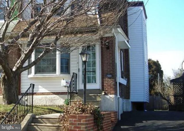 view of front facade featuring entry steps and brick siding