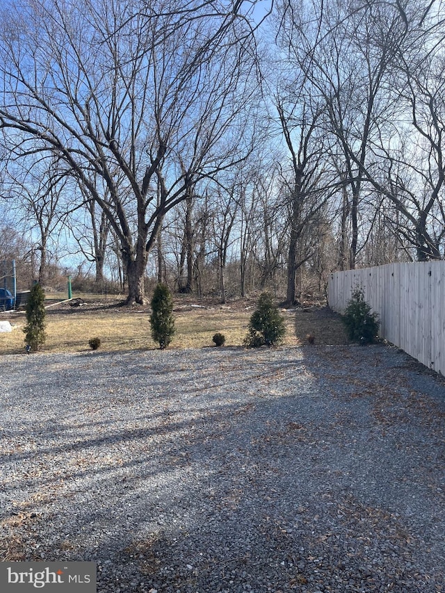 view of yard featuring driveway and fence