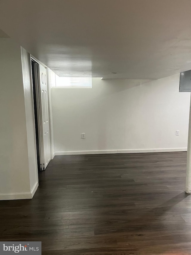 empty room featuring dark wood finished floors and baseboards