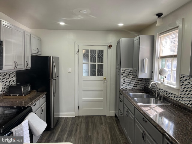 kitchen with baseboards, decorative backsplash, dark wood-style flooring, and a sink