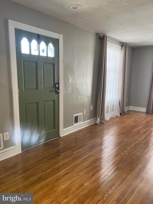 foyer entrance featuring visible vents, baseboards, and hardwood / wood-style flooring