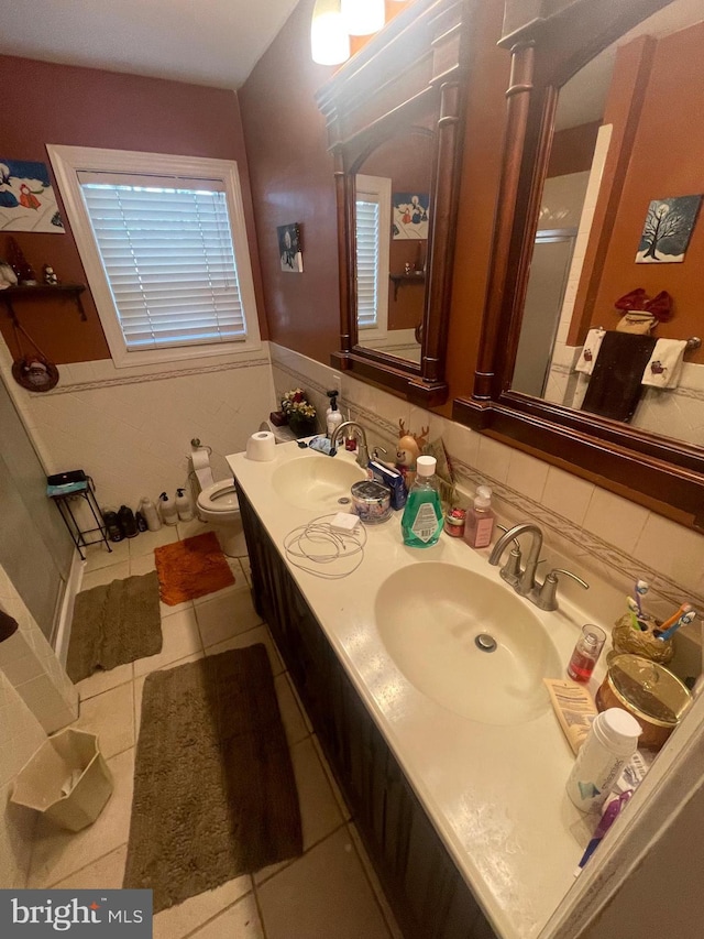 bathroom featuring a sink, a shower stall, toilet, and double vanity