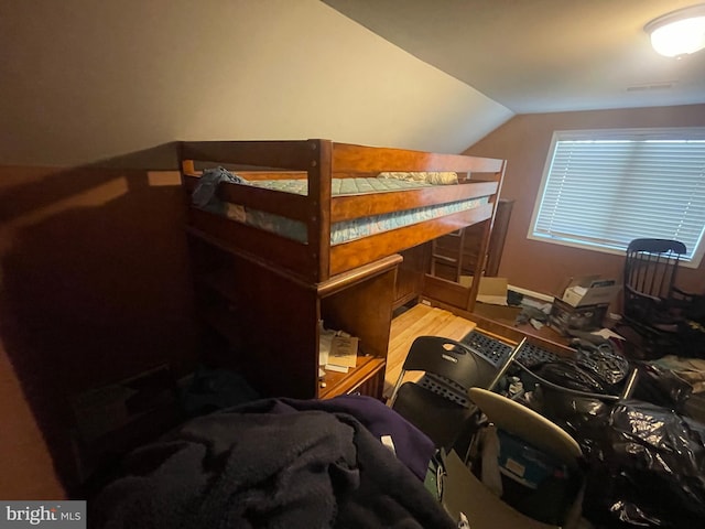 bedroom featuring lofted ceiling and wood finished floors