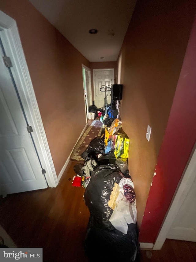 hallway featuring baseboards and wood finished floors