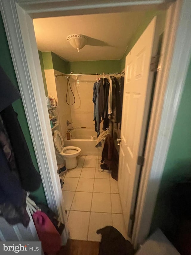 full bath with toilet, shower / tub combo with curtain, and tile patterned floors