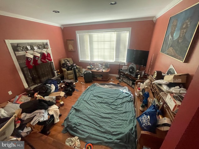 bedroom featuring ornamental molding and wood finished floors